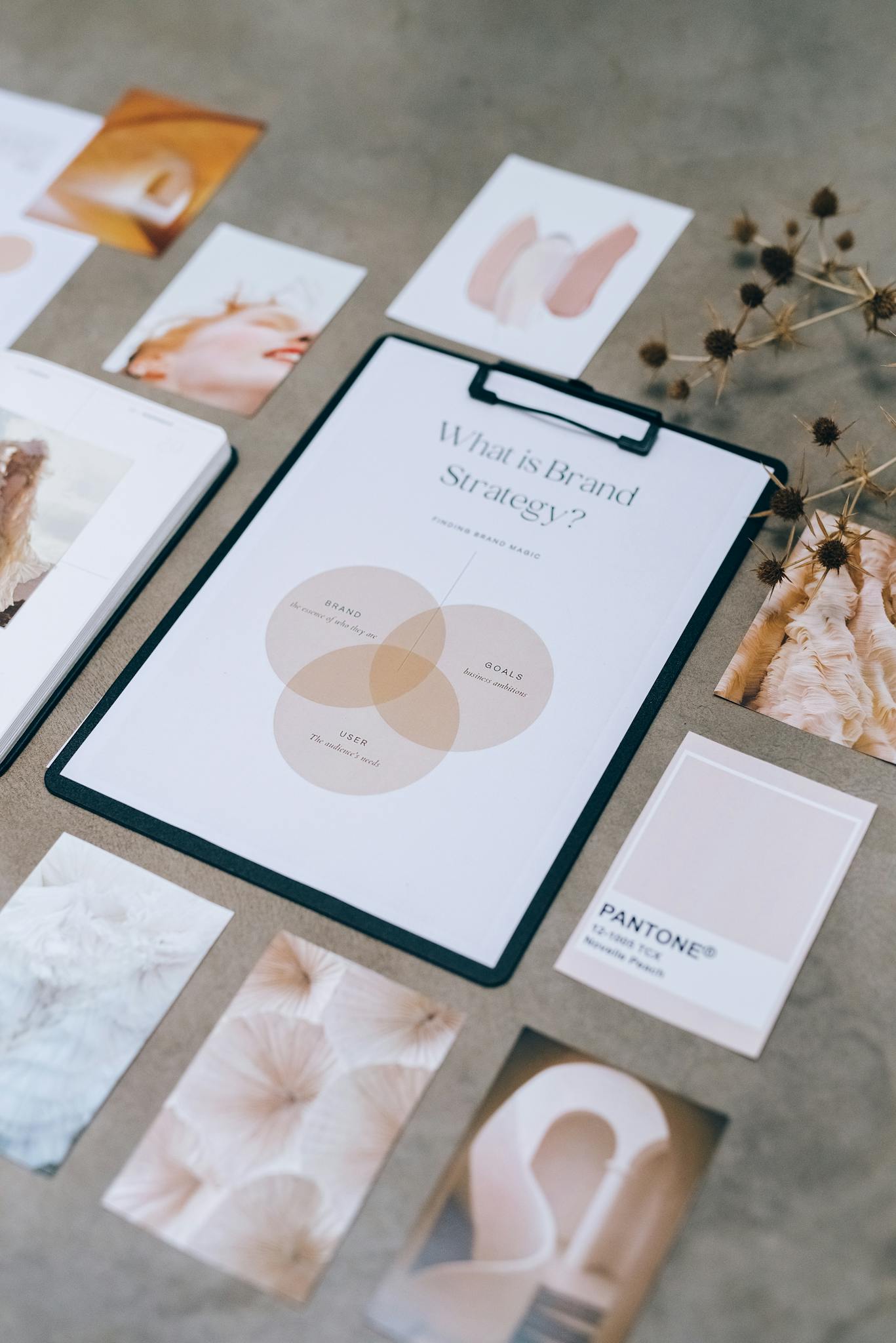 Flat lay of brand strategy clipboard with Pantone cards and aesthetic images on desk.